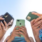 Tre personer som använder sina mobiler