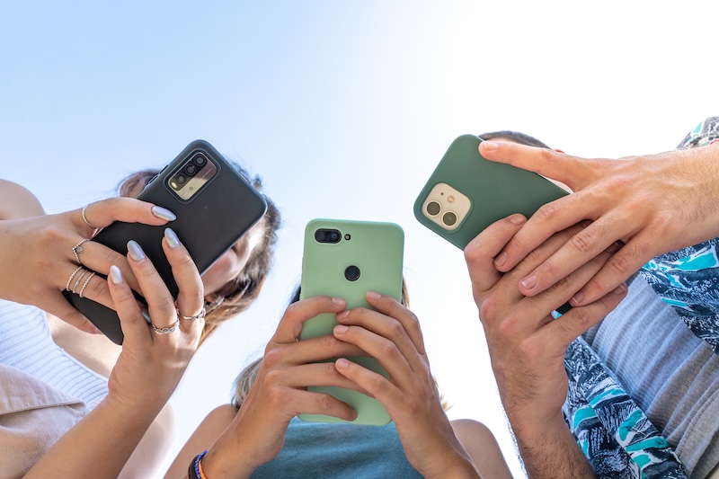 Tre personer som använder sina mobiler